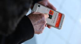 Imagen de las manos de una persona sujetando un teléfono móvil y utilizando una aplicación.