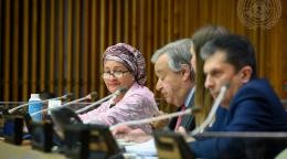 Une femme vêtue d'un châle et d'un foulard de couleur claire s’exprime dans un micro, aux côtés de deux hommes, en tournant la tête vers la caméra, lors d’une conférence organisée par l’ONU.