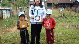 La Coordinadora Residente en Guatemala, Rebeca Arias Flores, promoviendo los Objetivos de Desarrollo Sostenible con la ayuda de dos pequeños en Nebaj, Quiché, durante una ceremonia de inhumaciones. 