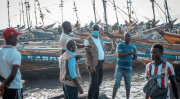 联合国驻地协调员参与可持续发展目标宣传活动，在离塞拉利昂首都弗里敦不远的沿海渔业社区汤博与船主讨论可持续发展目标13。