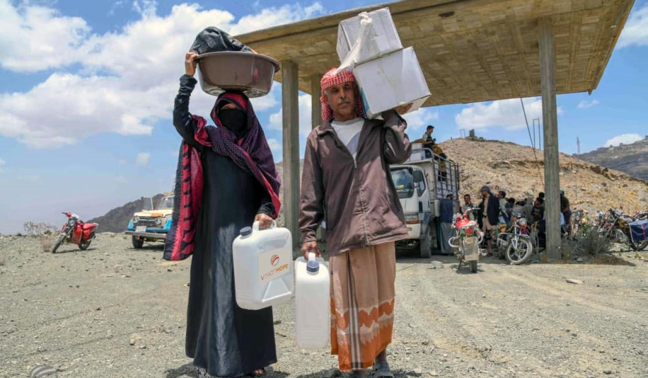 A displaced man and woman carry their rapid-response kit in Al Mahweet.