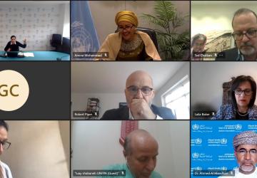 Screenshot shows a virtual meeting with nine men and women shown in nine squares across the screen.