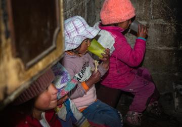 Cuatro niños bebiendo vasos de avena.