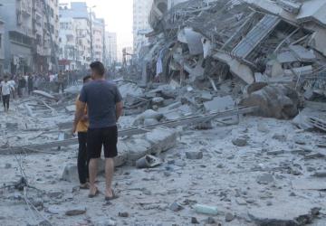 A group of men walk through the rubble of destroyed buildings in Gaza