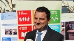 La imagen muestra a Philippe Poinsot siendo entrevistado frente a una cartelera con parte de los ODS.