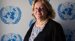 صورة رسمية تظهر ماريا أمام لافتة عليها عدة شعارات للأمم المتحدة.