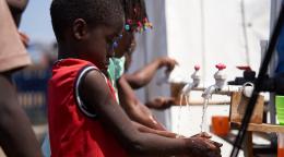 Children concentrate on washing their hands to prevent COVID-19. 