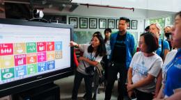Con motivo del lanzamiento del nuevo sitio web del equipo de las Naciones Unidas en Viet Nam, varios miembros del equipo de la oficina del Coordinador Residente se encuentran reunidos frente a una pantalla. Una joven muestra a sus colegas las novedades del sitio.