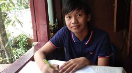 Thaw Lay, grade 10, from Yangon, Myanmar is shown studying at his home.