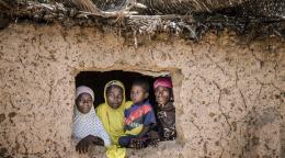 Two women with two children are shown within a window frame of their home in Niger.