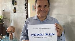 Un hombre sonríe dulcemente a la cámara mientras sostiene un pequeño letrero que comparte su visión de futuro sobre el sitio web, en español.