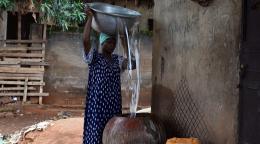 Adisa Abdul Rhaman vierte agua en su olla fuera de su casa.