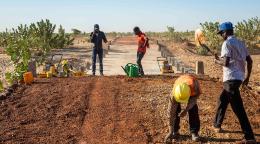 An image of four people working on a construction site in the desert. 