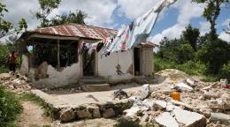 Photo d'une maison rurale endommagée par un tremblement de terre et dont une partie des murs a été détruite.