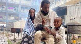 A family from Samre, in southwestern Tigray, sit together outside a large apartment complex.