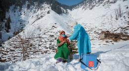 一名妇女在雪山接种COVID-19疫苗。