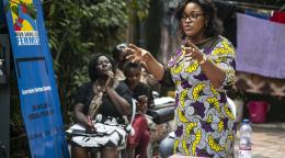 Fifi Baka, a feminist, human rights activist, and social entrepreneur living in the Democratic Republic of the Congo speaks at an event in front of other women.