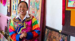 A smiling woman in thangka embroidery