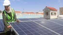一个女人正在修理太阳能电池板。