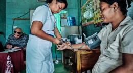 Une infirmière mesure la tension artérielle d'une patiente dans un établissement de santé de Kiribati.