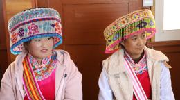 امرأتان من الأقليات العرقية في الصين ترتديان أغطية رأس وملابس ملونة.