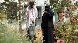 رجل وامرأة ترتدي الحجاب في حديقة صغيرة.