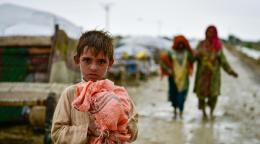 A child holds on to his belongings as families move to safer areas after floods in Balochistan province, Pakistan.