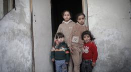 Four children in Syria standing at a doorway