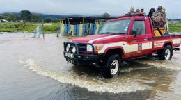 Red rescue truck in South Africa wading through water with people in it