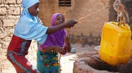 Des filles vont chercher de l'eau dans un puits devant leur maison à Dedougou, au Burkina Faso.
