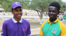 Two young men, one in a purple shirt and matching cap and another in a green and yellow shirt in Mozambique