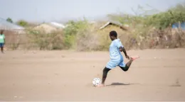 维纳斯足球俱乐部和皇后区足球俱乐部的女运动员们在肯尼亚卡库马难民营参加 2022 年世界难民日庆祝活动的足球友谊赛。