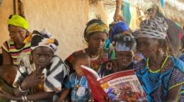 Группа женщин и детей изучает учебник Димитра