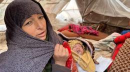 一名女性怀抱婴儿在地震后的救援帐篷里