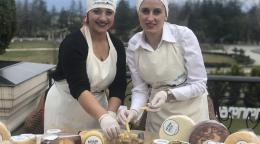 Two women selling cheese in an outdoor setting
