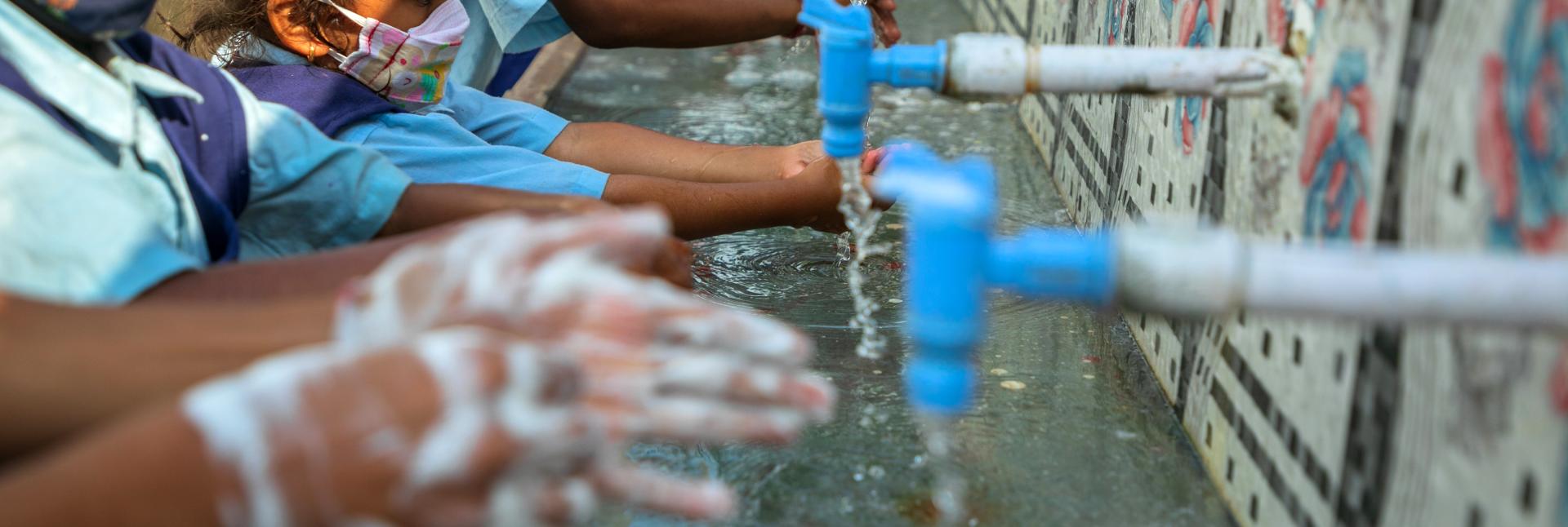 school kids using hand washing facilities