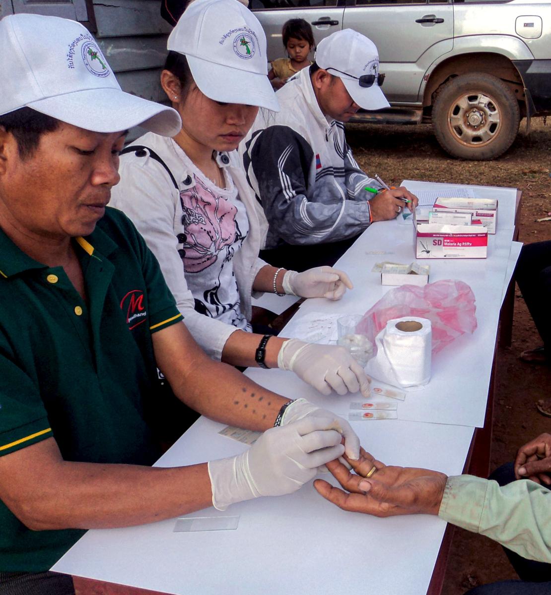 يقوم الموظفون في مركز الوقاية من الملاريا والقضاء عليها بإجراء اختبارات التشخيص السريع للمرض.