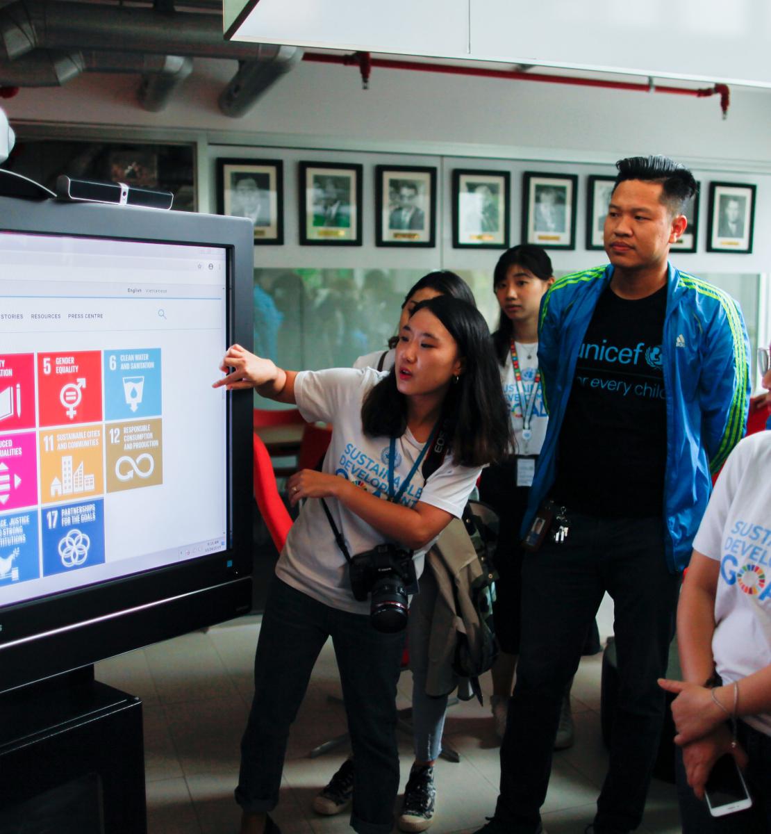 A l’occasion du lancement du nouveau site web de l’équipe de l’ONU au Viet Nam, plusieurs membres de l’équipe du bureau du Coordonnateur résident sont réunis devant un écran. Une jeune femme montre à ses collègues les nouvelles fonctionnalités du site.