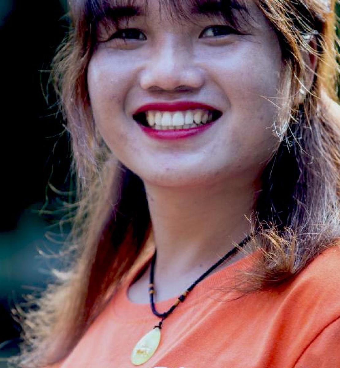 Primer plano de Kim Thuy, quien tiene una gran sonrisa en su rostro, mirando a la cámara. Kim Thuy es una activista transgénero de Vietnam que sueña con organizar un desfile del orgullo gay en la comunidad donde creció.