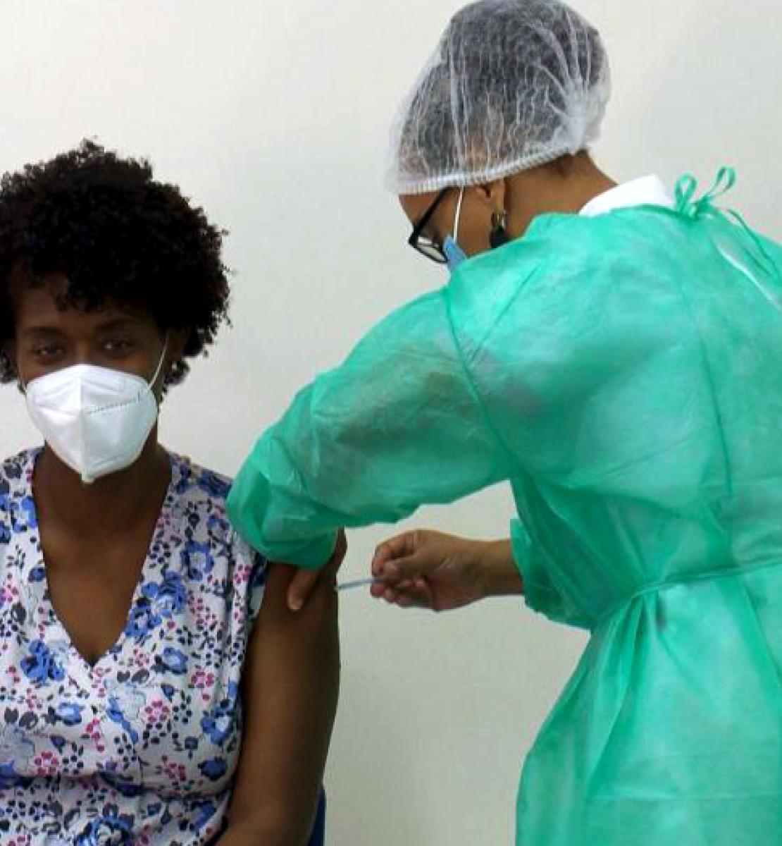 Ana Manuela, una técnica de salud, se sienta con tranquilidad, mientras recibe la vacuna contra la COVID-19.
