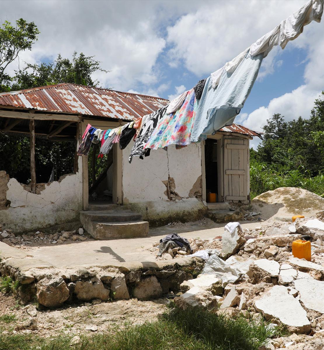 Photo d'une maison rurale endommagée par un tremblement de terre et dont une partie des murs a été détruite.