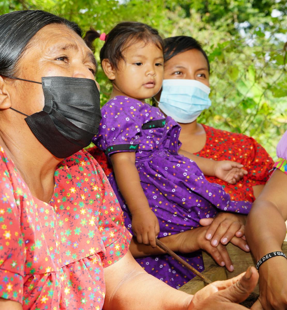 Tres mujeres indígenas Naso Tjër Di y una niña en su huerto comunitario.