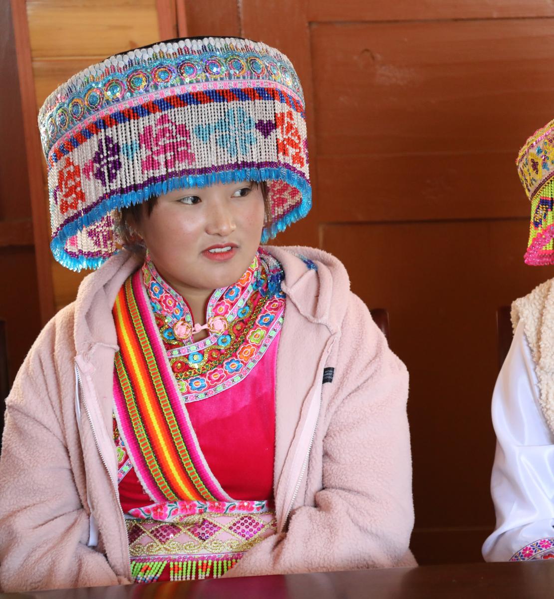 2 women from ethnic minority groups in China wearing colourful headwear and clothing