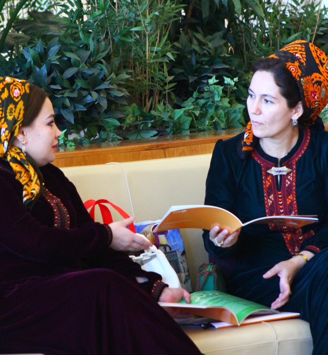 Две женщины обсуждают публикацию на мероприятии.