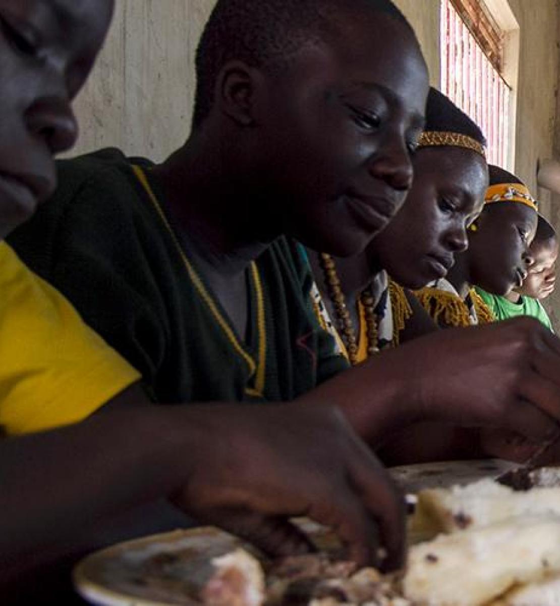  乌干达里拉综合养鱼场的学生们正在吃午餐，该渔场是农业和粮食安全南南合作机构。 