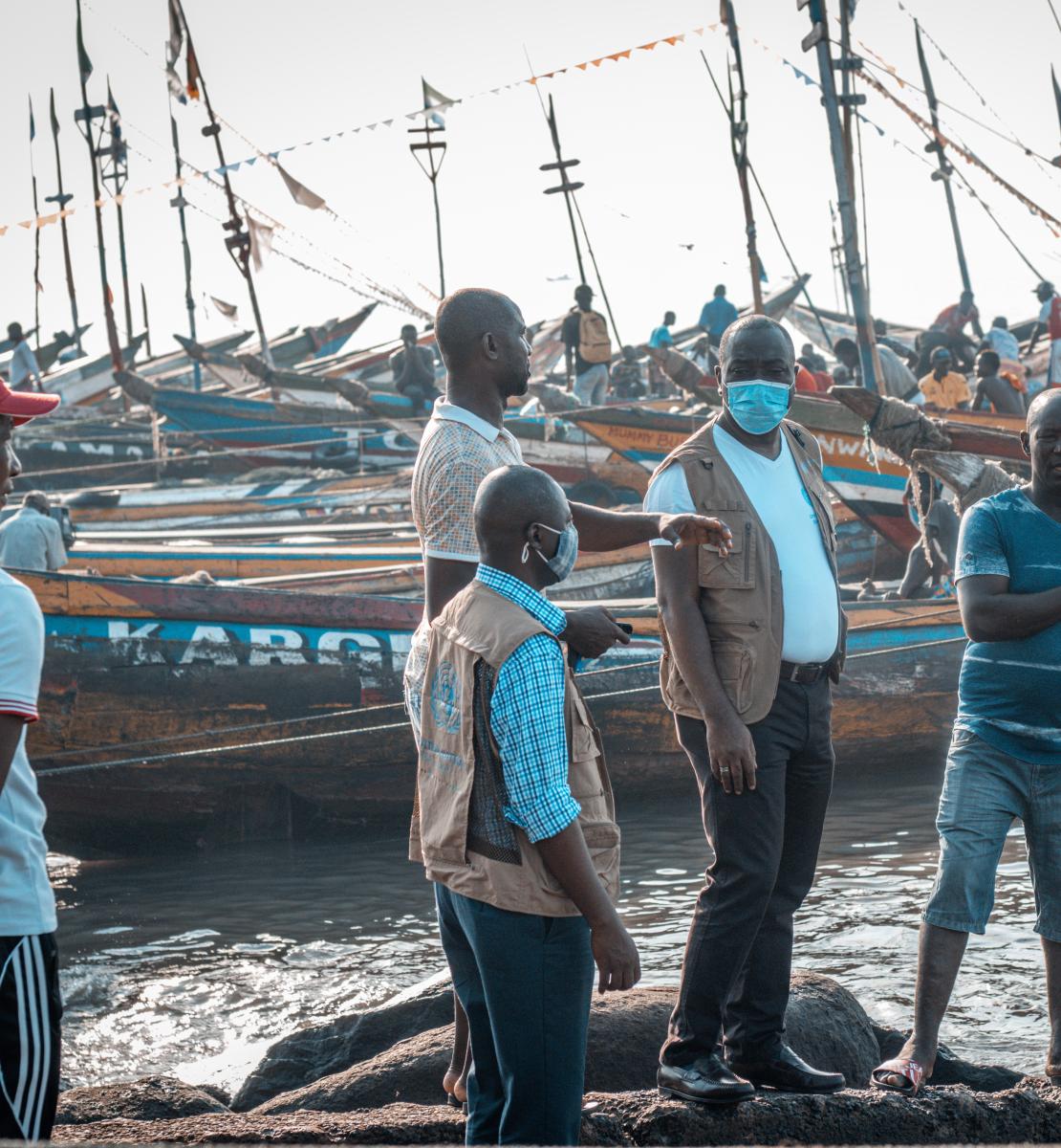 Le Coordonnateur résident des Nations Unies en Sierra Leone discute de l'ODD 13 avec des propriétaires de bateaux à Tombo, une localité côtière de pêcheurs située non loin de Freetown, la capitale de la Sierra Leone.