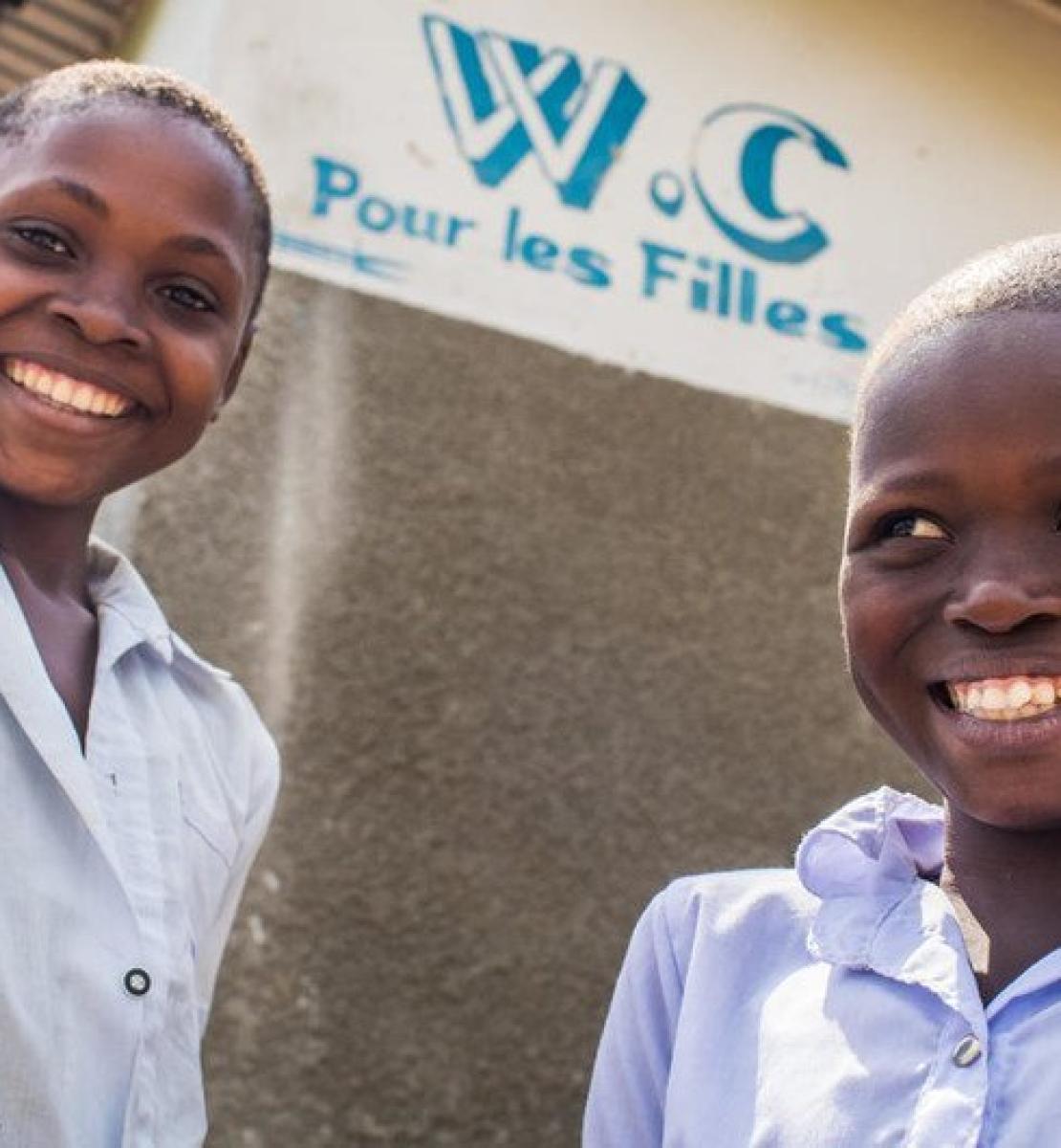 刚果民主共和国西部开赛省卡南加迪科莱拉伊小学厕所外的两名学生卫生队员在面对镜头微笑。