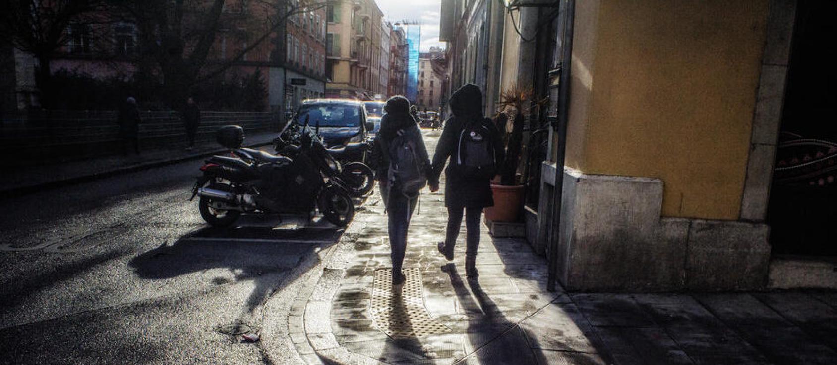 两人手牵手在街上走的背影。