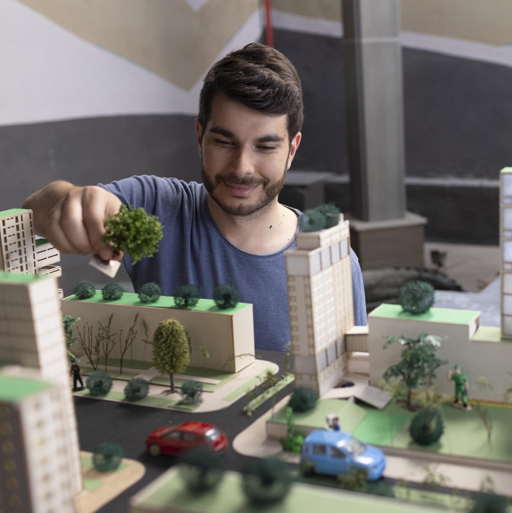 Gorjan Jovanovski, founder of the start-up AirCare works on a model city. 