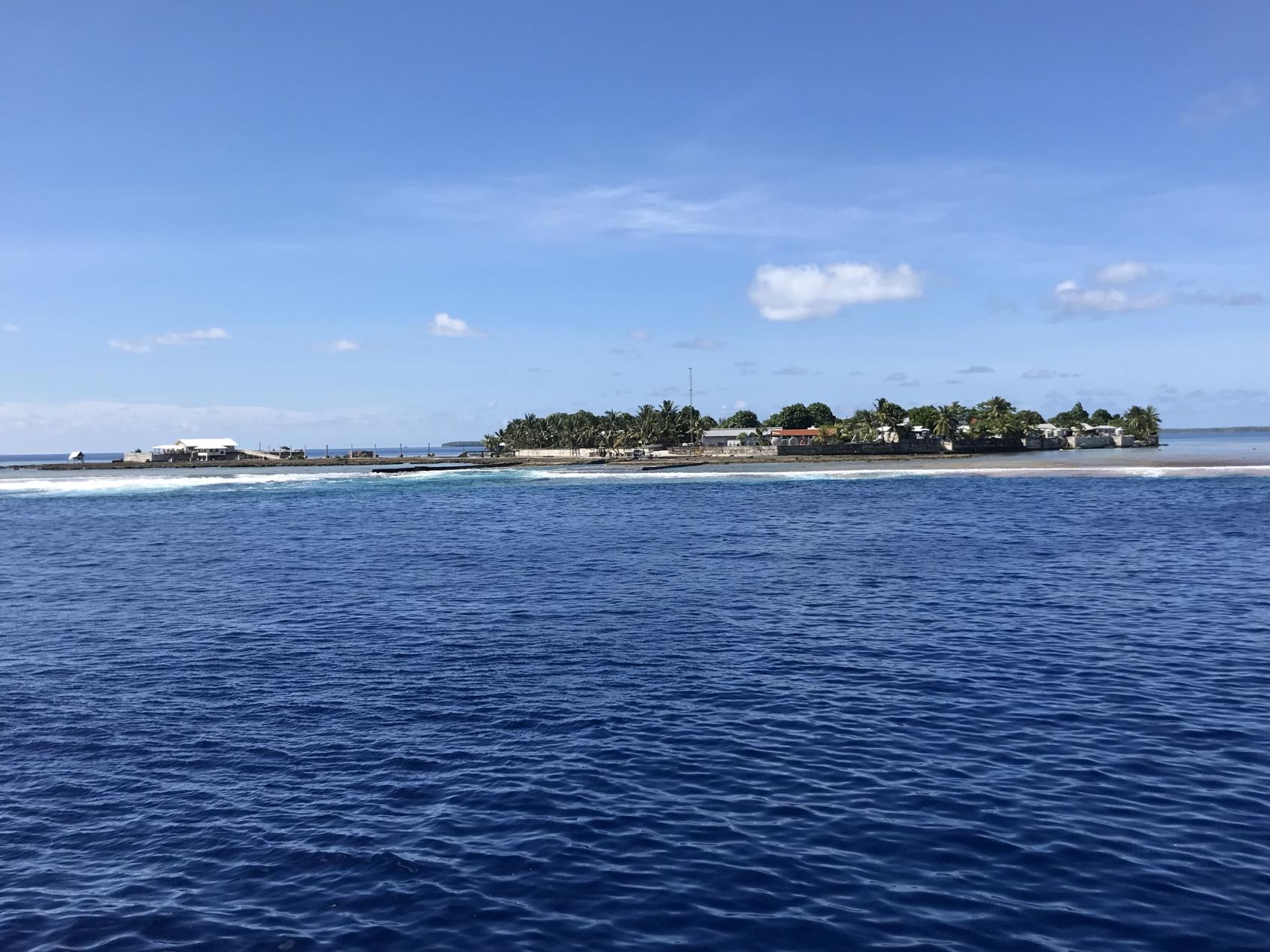 A landscape view of a small island nation where homes and commerce visible from the ocean. 